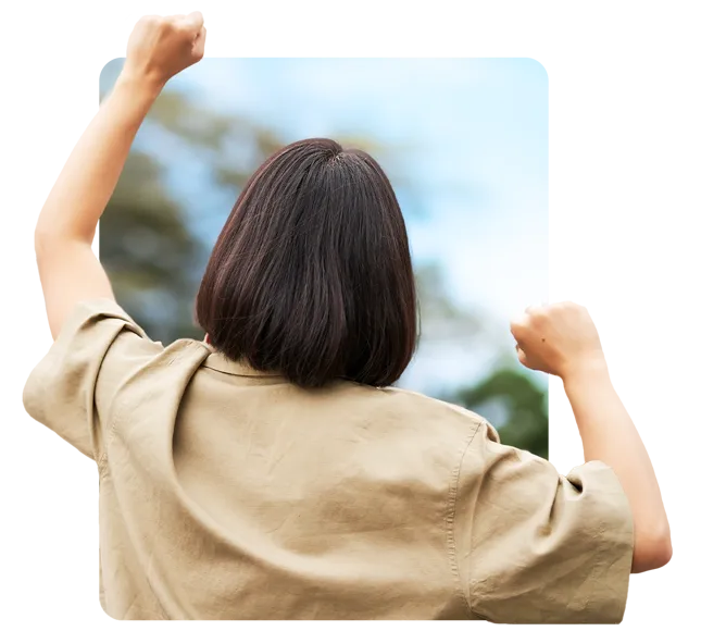 A woman seen from behind with both fists raised